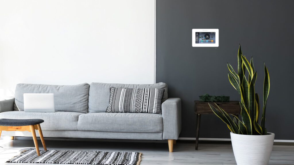 Living room with MagIQtouch controller on wall above sofa