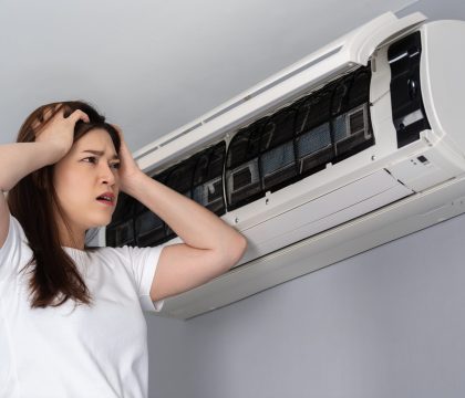 stressed young woman has problem with the air conditioner at home